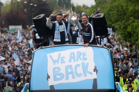 Coventry captain Matt Grimes and manager Frank Lampard hold the Championship trophy on top of a bus at the victory parade