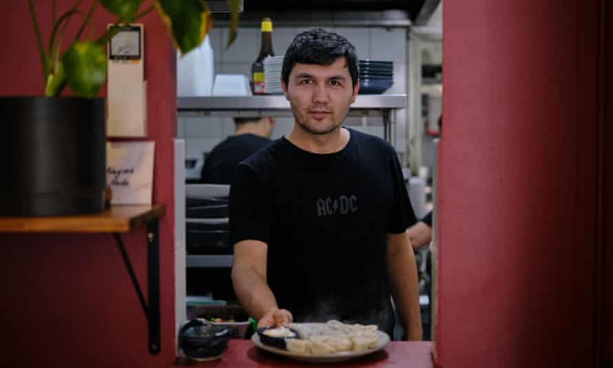 Elzhe Pahir, bucătar și manager la Tarim Uyghur Handmade Noodles servește faimoasele lor găluște