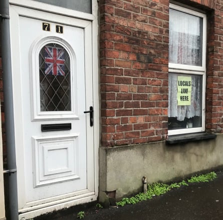 A house in Ballymena with a union jack and ‘Locals live here’ poster taped to windows.