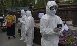 Epidemic control workers wear protective suits as they wait to assist people who have had contact with the Xinfadi wholesale market.