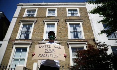 A protester wearing a face mask displays a message that reads: 'Where was your sacrifice?' near the home of Dominic Cummings, Boris Johnson's chief aide