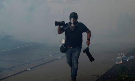 A photographer runs amid teargas in Minneapolis, Minnesota, on 30 May. 