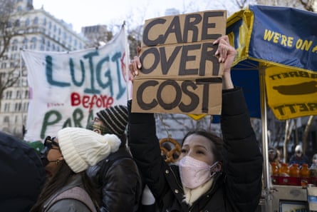 protesters hold signs in support of luigi mangione