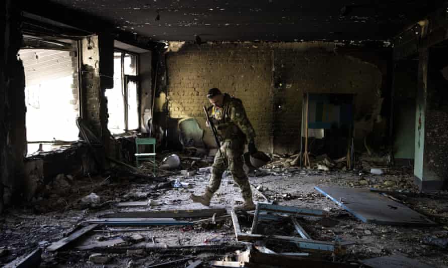 A Ukrainian serviceman inspects a school damaged during a battle between Russian and Ukrainian forces in the village of Vilkhivka, in eastern Ukraine.