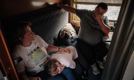 Solomia, 9, takes a nap on her mother’s lap on a train from Warsaw approaching the central station in Kyiv on January 26, 2023. Solomia’s parents went to Poland for agricultural trade meetings and bought two ambulances to donate to Ukrainian soldiers on the front line.