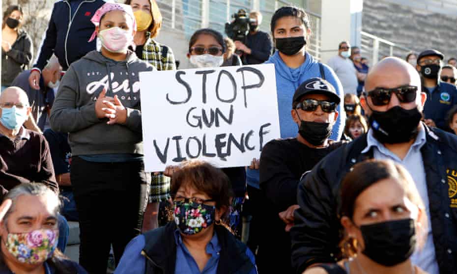 A girl holds a sign that says 'stop gun violence' as people attend a vigil for the victims of a shooting in San Jose, California, on May 2021.