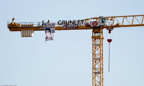 Manuel Oliver displays a banner calling on government officials to prioritize gun violence prevention from a construction crane near the White House.
