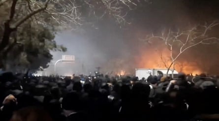 Smoke rises as protesters gather amid evolving anti-government unrest at Vakilabad highway in Mashhad.