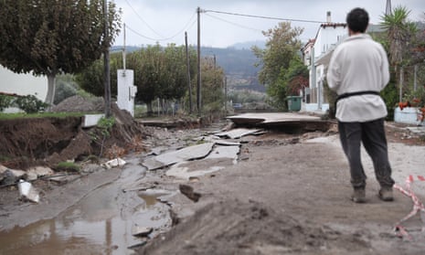 A man looks at a destroyed road after heavy rain in Evia, Greece.