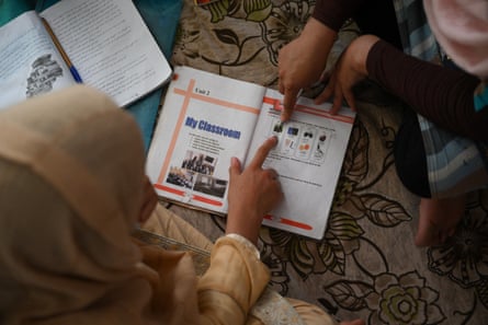 Top-down shot of girl studying English words in a book on the floor