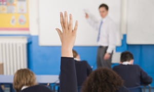 A pupil raising their hand to attract a teacher's attention