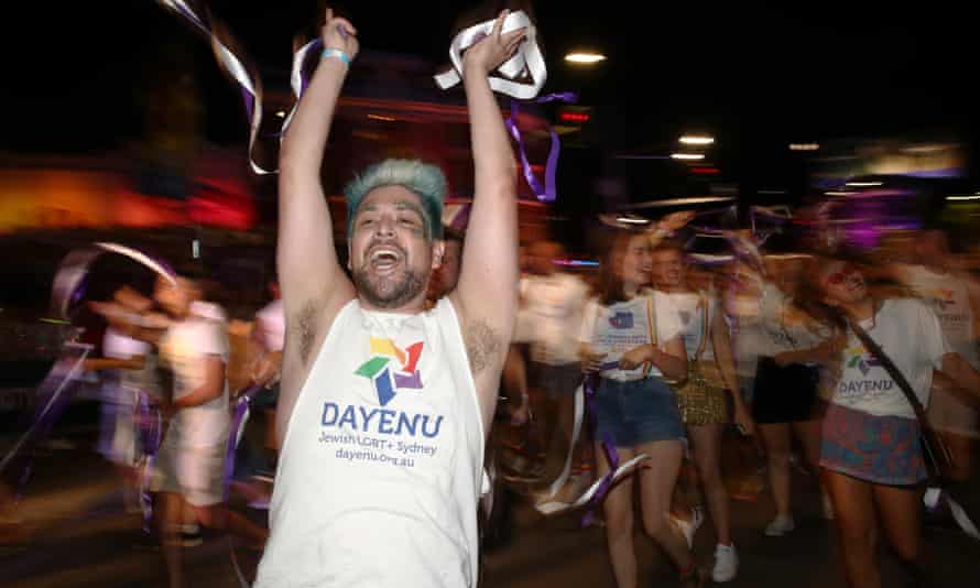 A man throws up his arms with delight at the Sydney Gay and Lesbian Mardi Gras