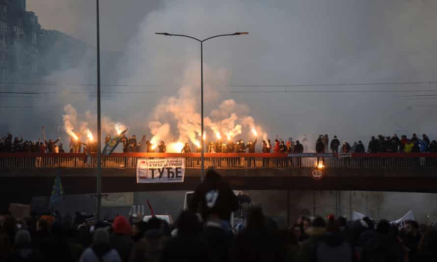 Manifestantes acenam chamas durante uma manifestação em Belgrado contra a proposta do governo para uma mina de lítio.