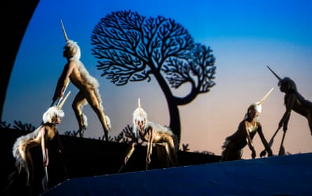 Four actors dressed to look like unicorns with the silhouette of a tree
