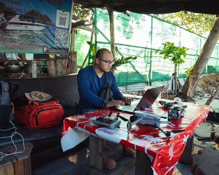 A man sitting at a desk looking at a computer