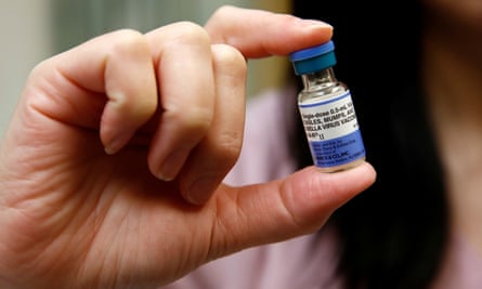 Closeup of someone holding a phial of the MMR vaccine