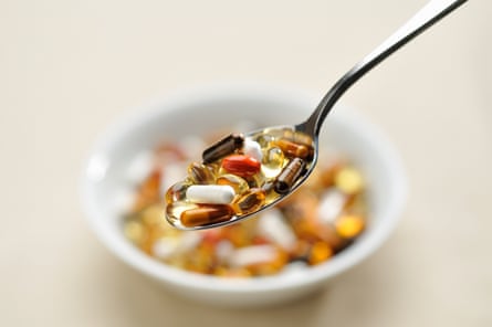 Spoonful of supplements and vitamins, with a bowl in the background