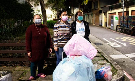 Women wait for their government-issued bin bags to be collected in Taipei.