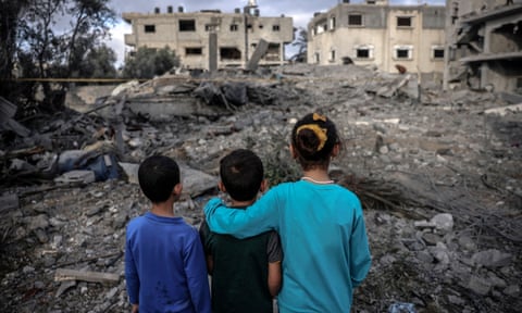 Children stand amid the rubble of a building hit by an Israeli air strike in the centre of the Gaza Strip.