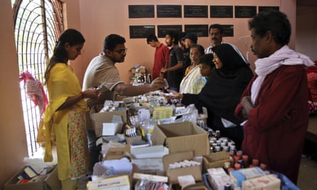 Volunteers give medicine to people in a relief camp on the outskirts of Kochi, Kerala.
