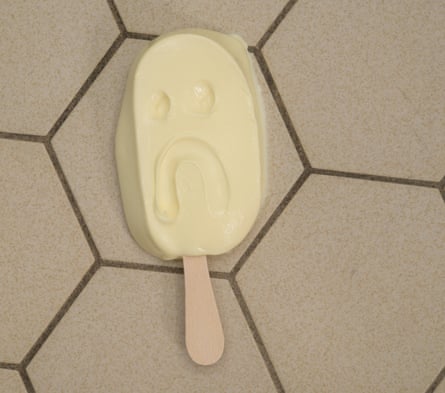 A Magnum ice-cream on the floor, with eyes and a downturned mouth drawn into it