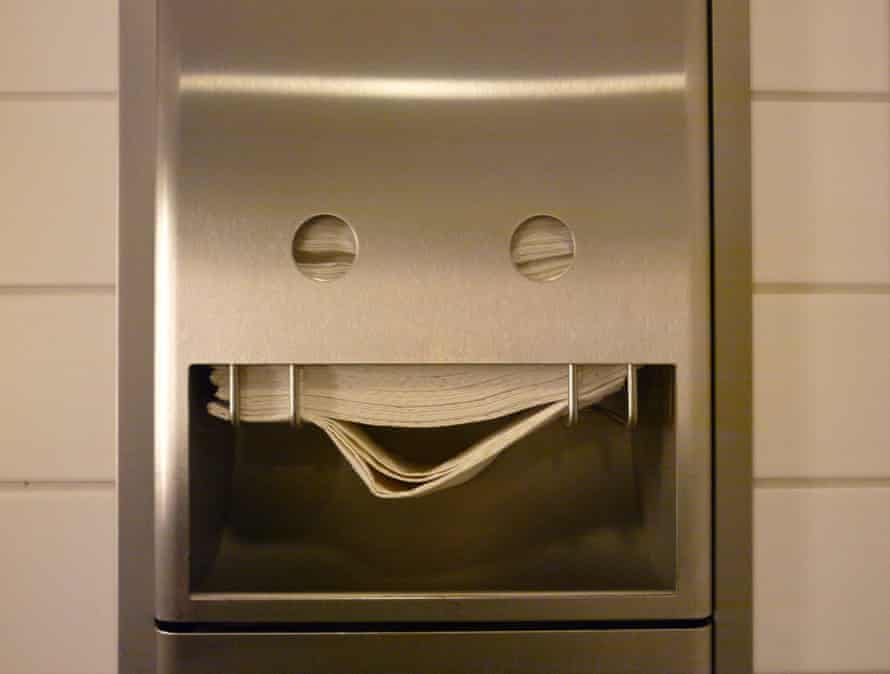 Un distributeur de serviettes dans une salle de bain publique qui semble sourire