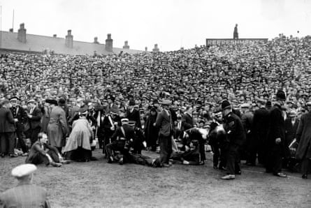Des ambulanciers assistés par la police s'occupent des blessés lors de la demi-finale de la FA Cup entre Arsenal et Grimsby Town en 1936.