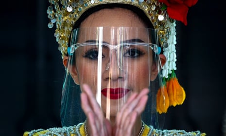 A dancer wearing a protective face shield performs at a temple in Bangkok