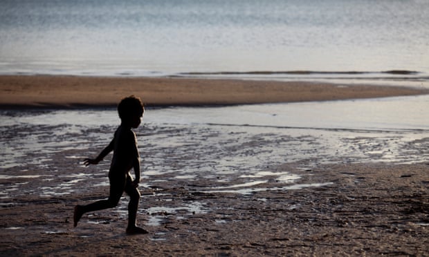 Aboriginal boy running on beach at Nyinykay Homeland.