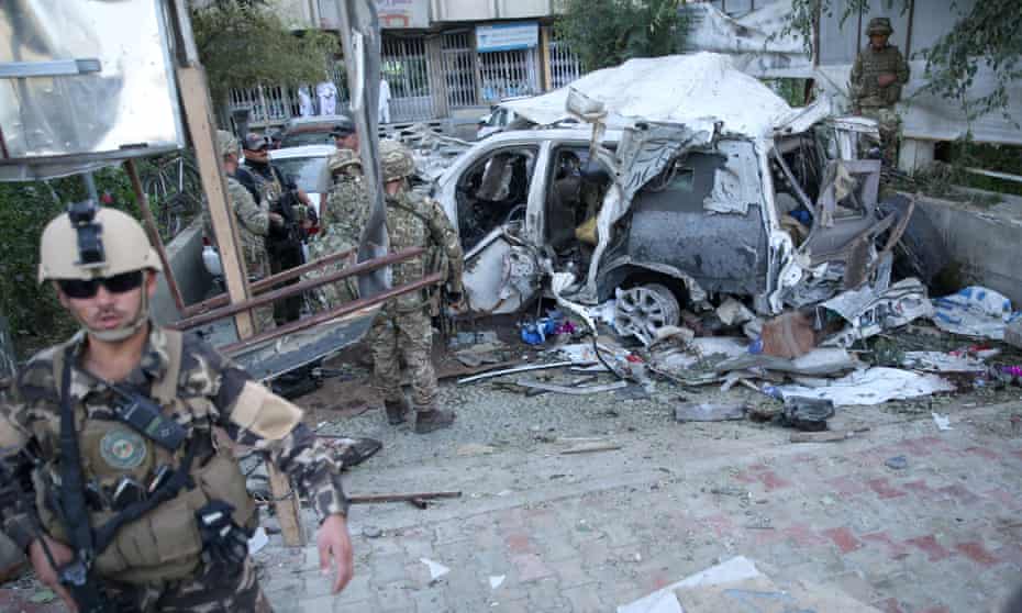 Afghan security forces and British soldiers inspect the site of a suicide attack in the heart of Kabul, Afghanistan.