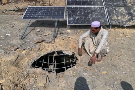 A villager examines the damaged rooftop of a mosque.