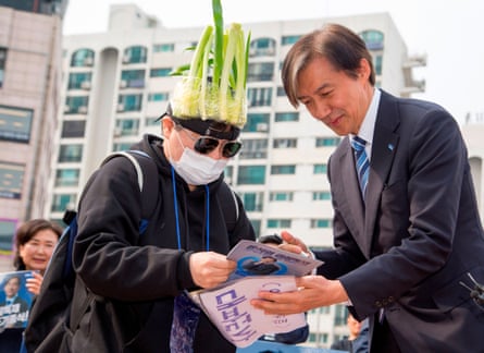 Cho Kuk of the Rebuilding Korea party greets a supporter wearing a cap covered with green onions in Seoul on Saturday.