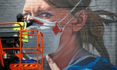An artist works on a mural during the coronavirus pandemic in Manchester.