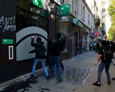 Protesters destroy a bank window during clashes at a demonstration in Paris.
