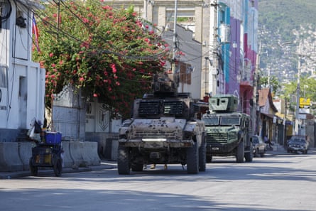 armored vehicles drive along a street