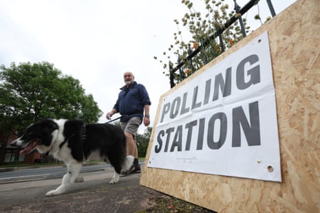 A person at the St Aidan’s Parish Centre polling station with their dog in Wigan, Britain, 18 June 2026.