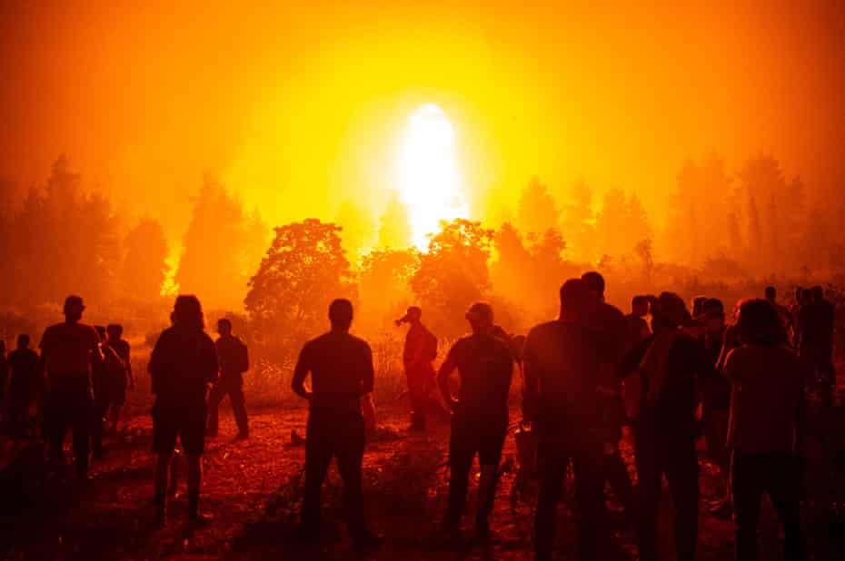 Local youths and volunteers wait to support firefighters during a wildfire next to the village of Kamatriades in Greece.