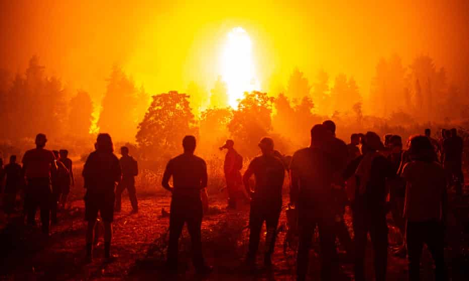 Volunteers support firefighters tackling a wildfire next to the village of Kamatriades on the Greek island of Evia.