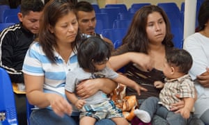 Mothers and children wait to be assisted by volunteers in a humanitarian center in the border town of McAllen, Texas, on 18 June.