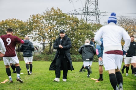 The Wythenshawe manager, Kieran Megran, stands among players warming up