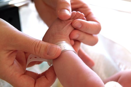 Adult hands clasp a newborn’s ft arsenic they connect an personality set astir its ankle