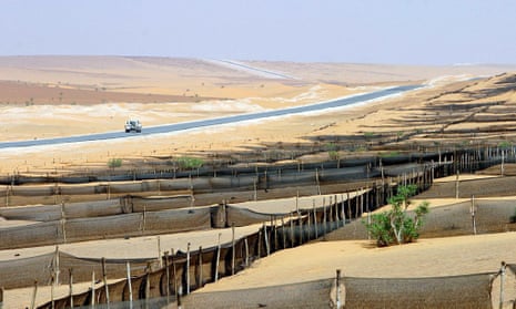 A vehicle travels along a completed stage of the Trans-Sahara Highway. 