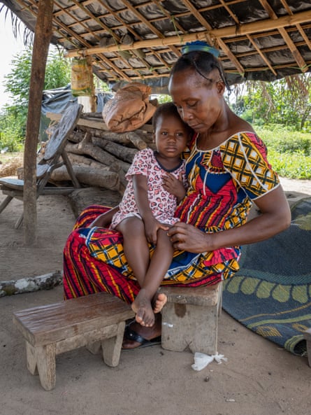 Marilou caring for one of her grandchildren in their home in an Ivory Coast village.