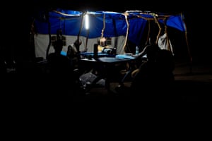 Staff members from Unicef and the World Food Programme work late into the night, sorting registration tokens by the light of a solar powered lamp