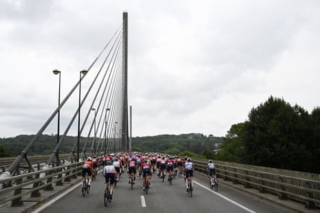 The peloton cross a bridge in the early kilometres