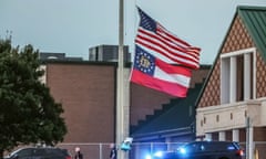 The US and Georgia flags fly at half-staff in front of buildings