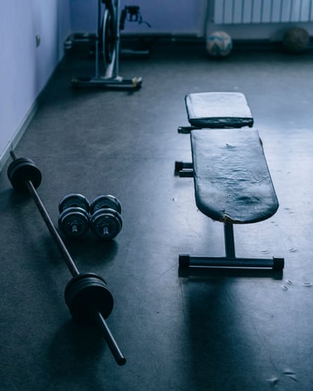 Room with a plain concrete floor and some weights and a bench