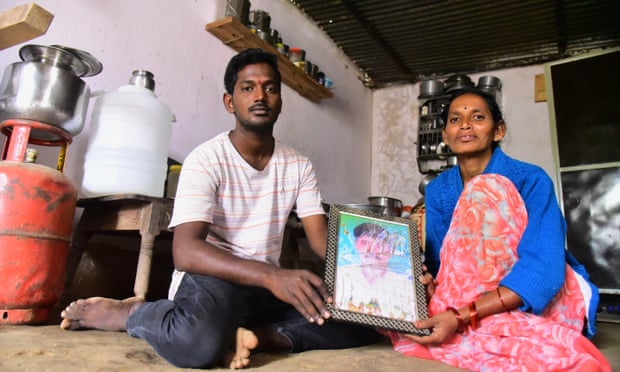 Latha Bollapally, with her son Rajesh Goud, holds a picture of her husband, Madhu Bollapally, 43, a migrant worker who died in Qatar