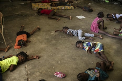  Children sleep on the floor of a Port-au-Prince school that was turned into a shelter after they were forced by gang violence to leave their homes.