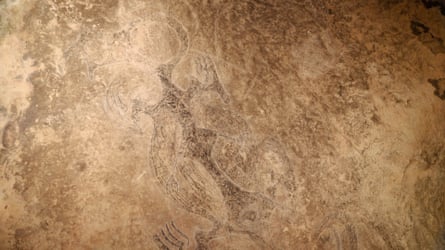 Faint image of a four-limbed water spirit with a hollow round head, drawn in black on pale beige stone